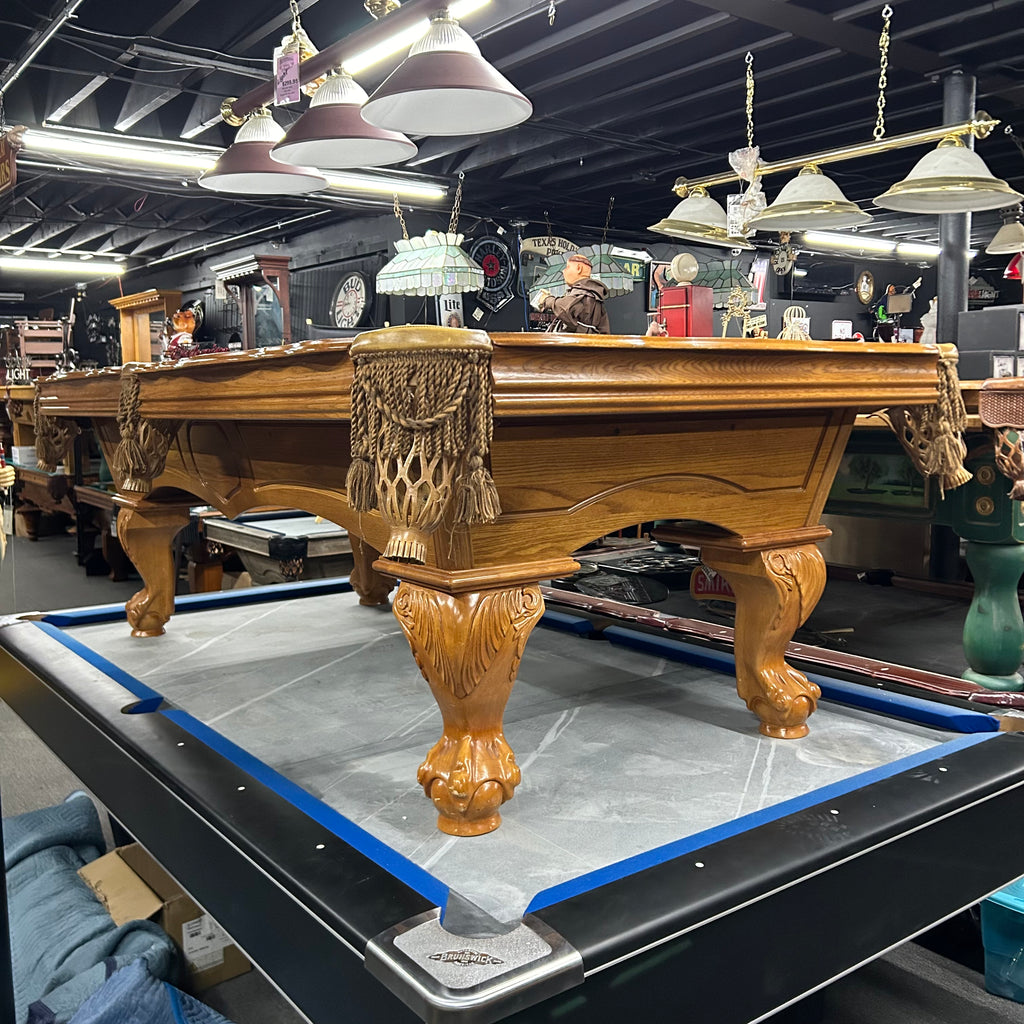 Overall view of american heritage pool table in oak finish with tassel fringe pocket and rams horn leg