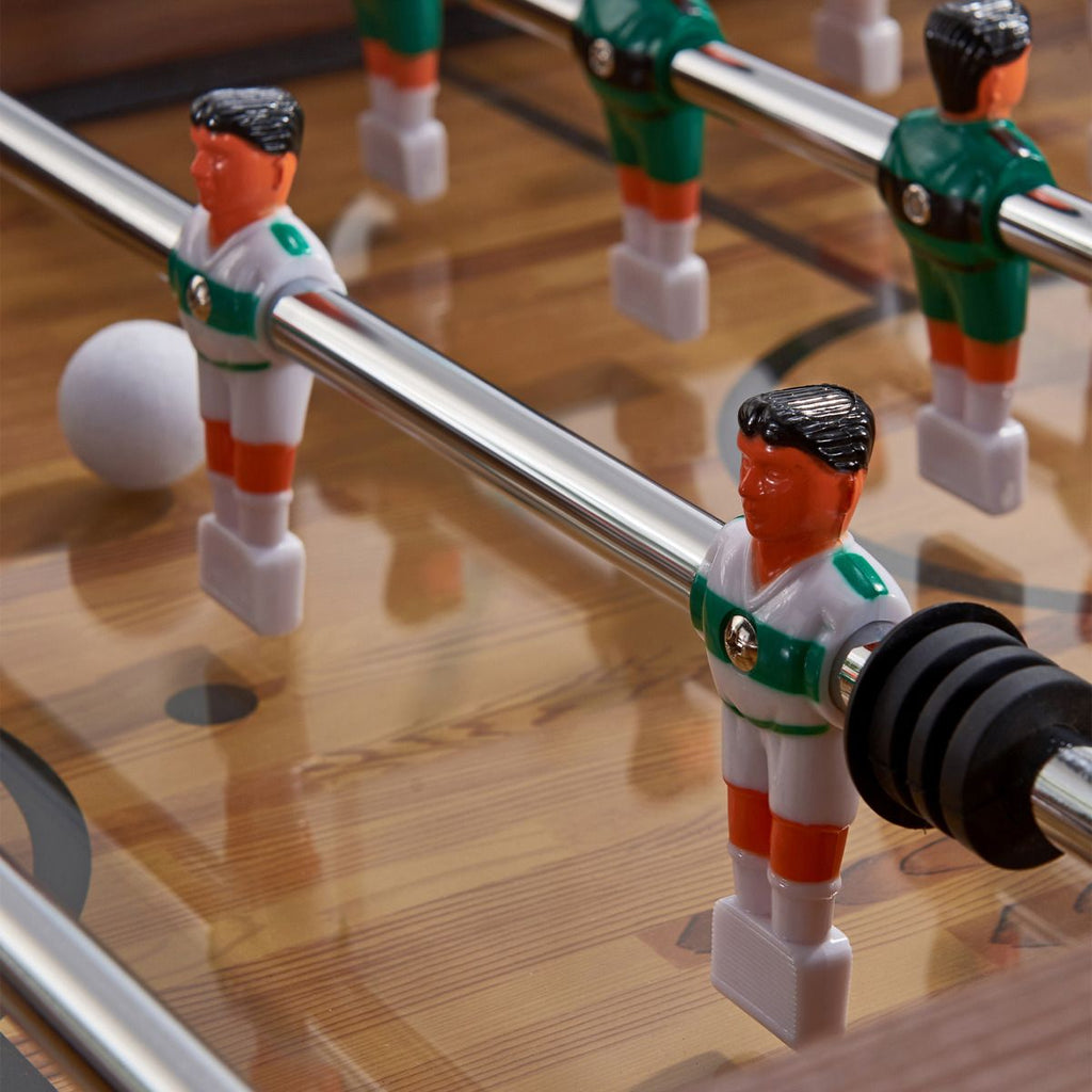 close up of foosball man with green and white striped jersey