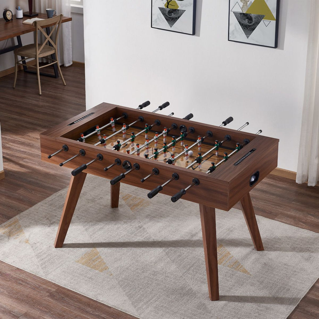 foosball table on top of white rug in front of white wall