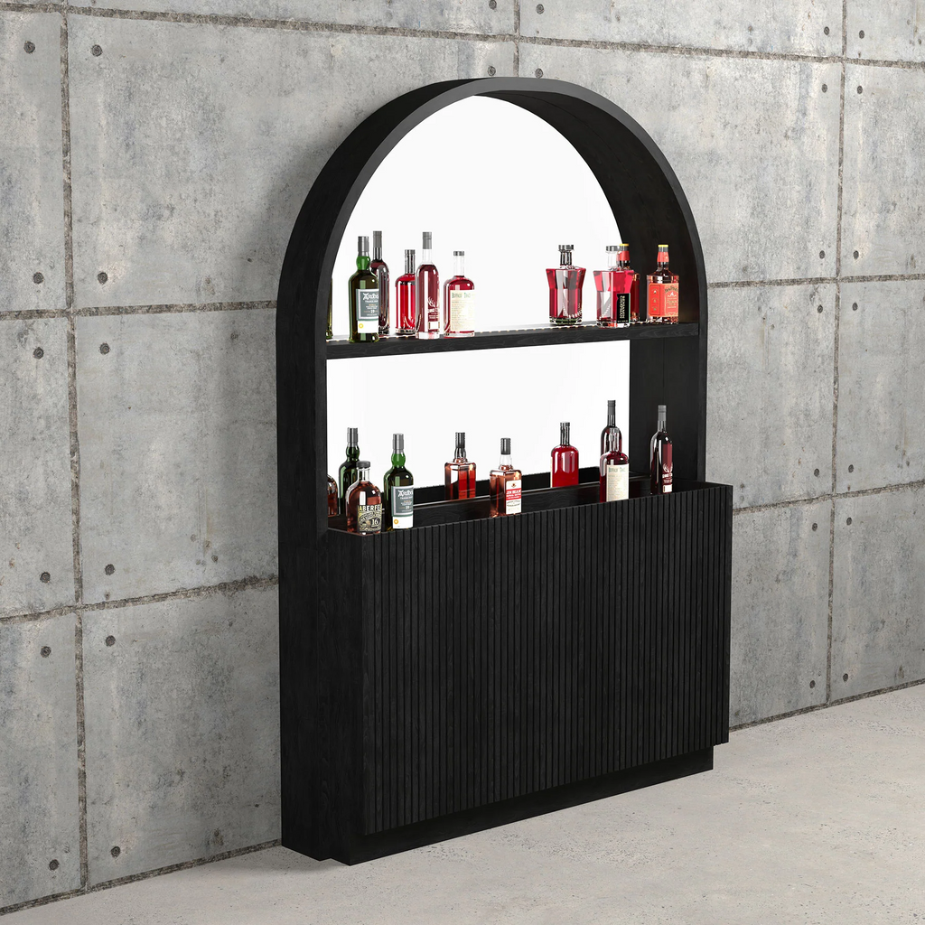 Black bar unit in room against concrete wall with bottles on it