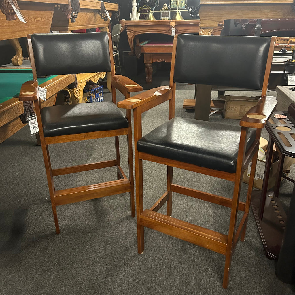 Pair of wooden bar stools with black leather seats close up