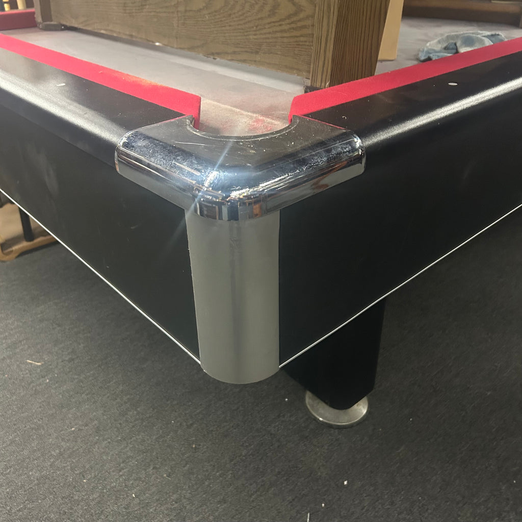 Chrome corner castings on pool table with red cloth and black finish