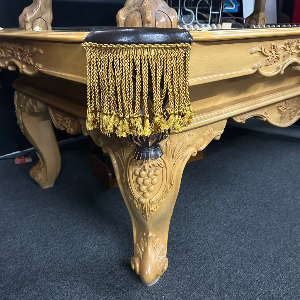 Corner view of pool table with gold fringe pockets and custom ornate rams horn leg