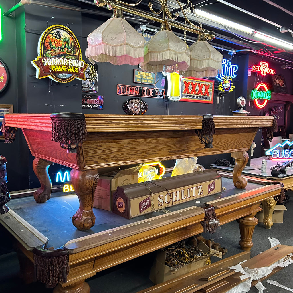 Overall view of Olhausen oak pool table with ball and claw leg and fringe pocket