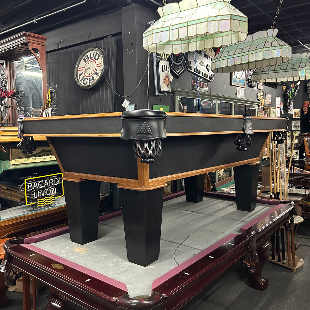 Overall view of black and oak pool table with tapered leg and black pocket