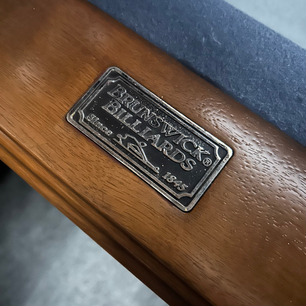 Brunswick billiards label on pool table rail with blue felt