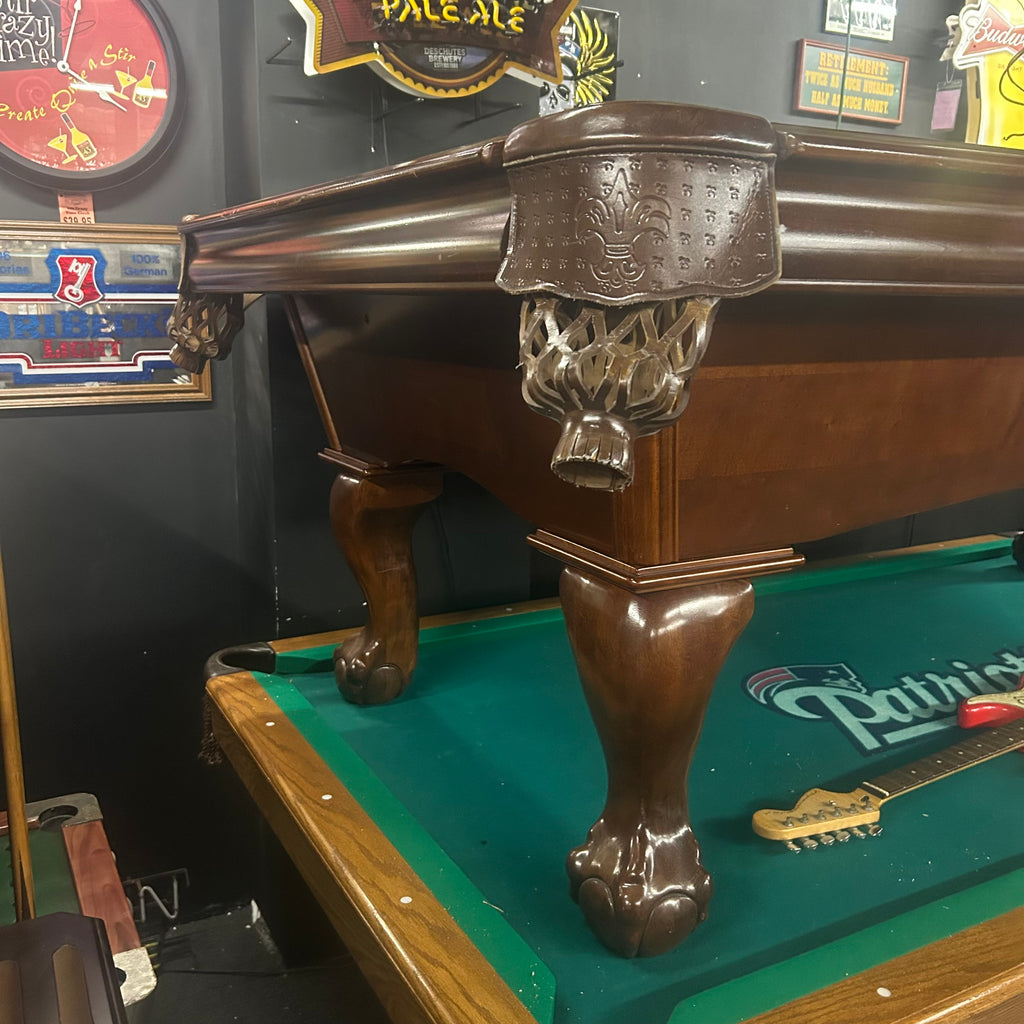 Corner view of pool table with walnut finish and leather shield pocket and ball and claw leg