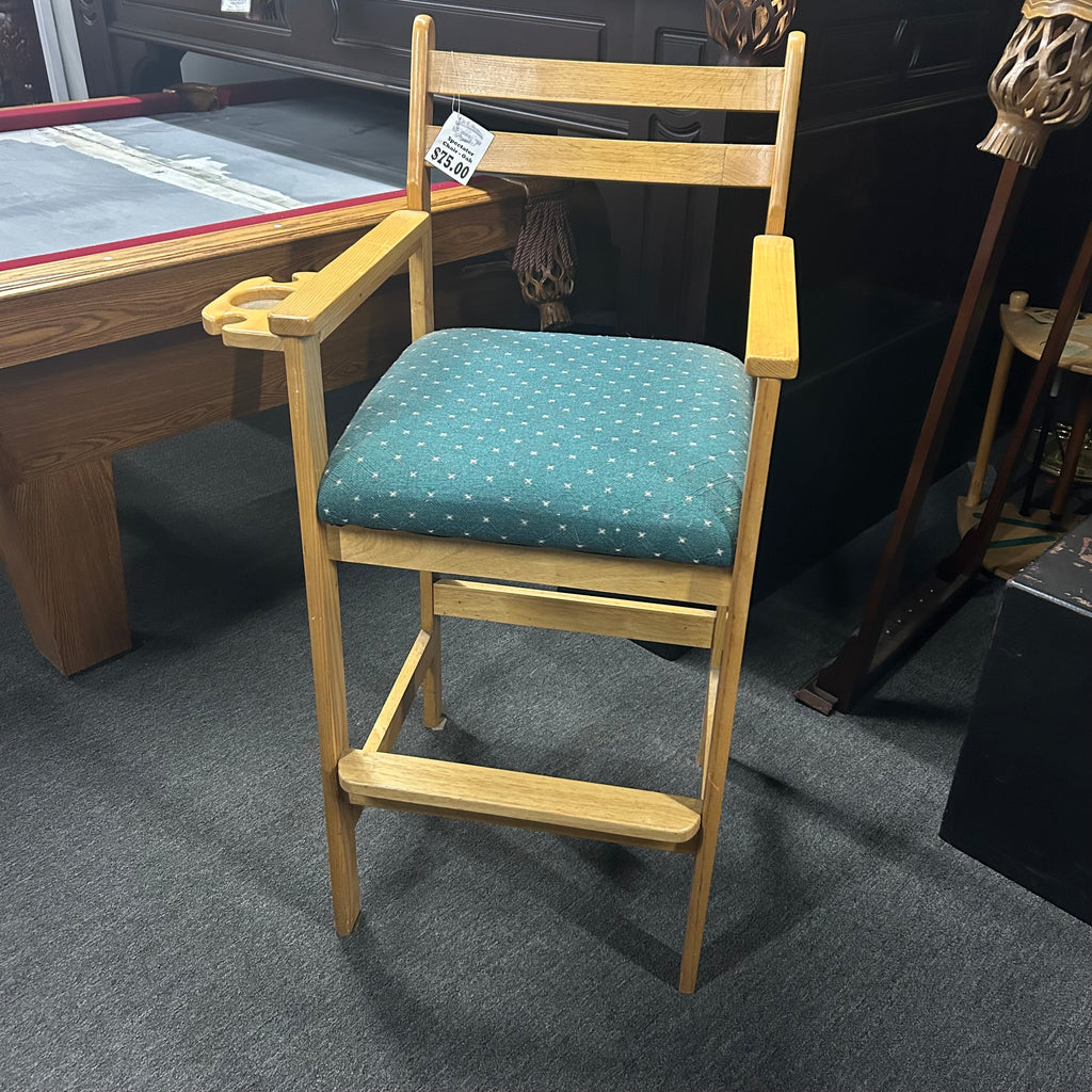 Wooden chair with a green cushion on a gray floor