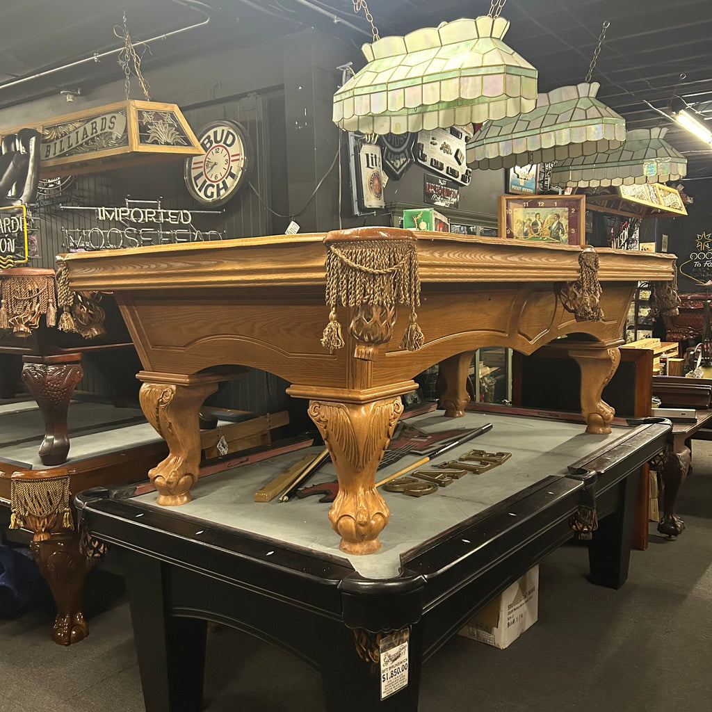 Oak  pool table with ornate wooden finish in a room with various decor elements