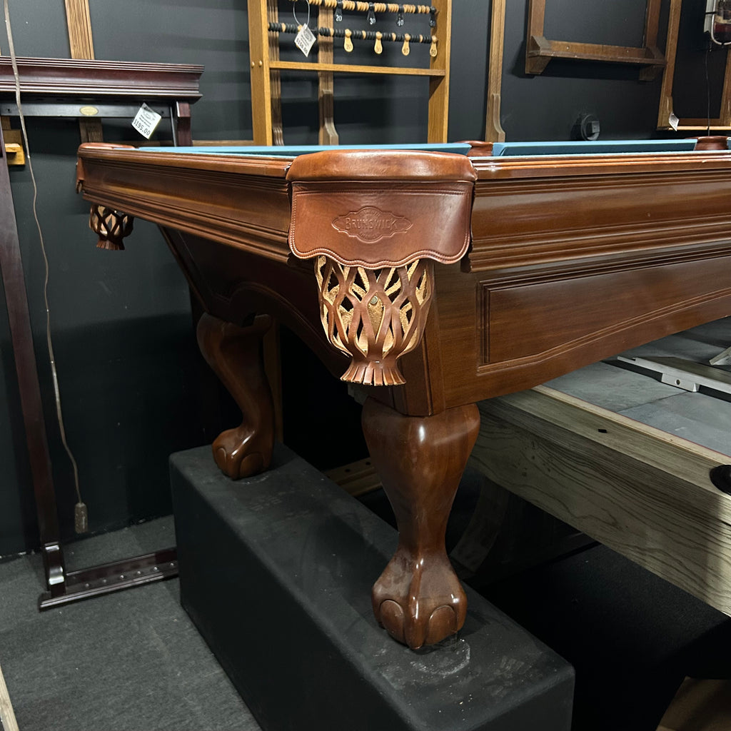 Corner view of pool table with ball and claw leg and shield pocket 