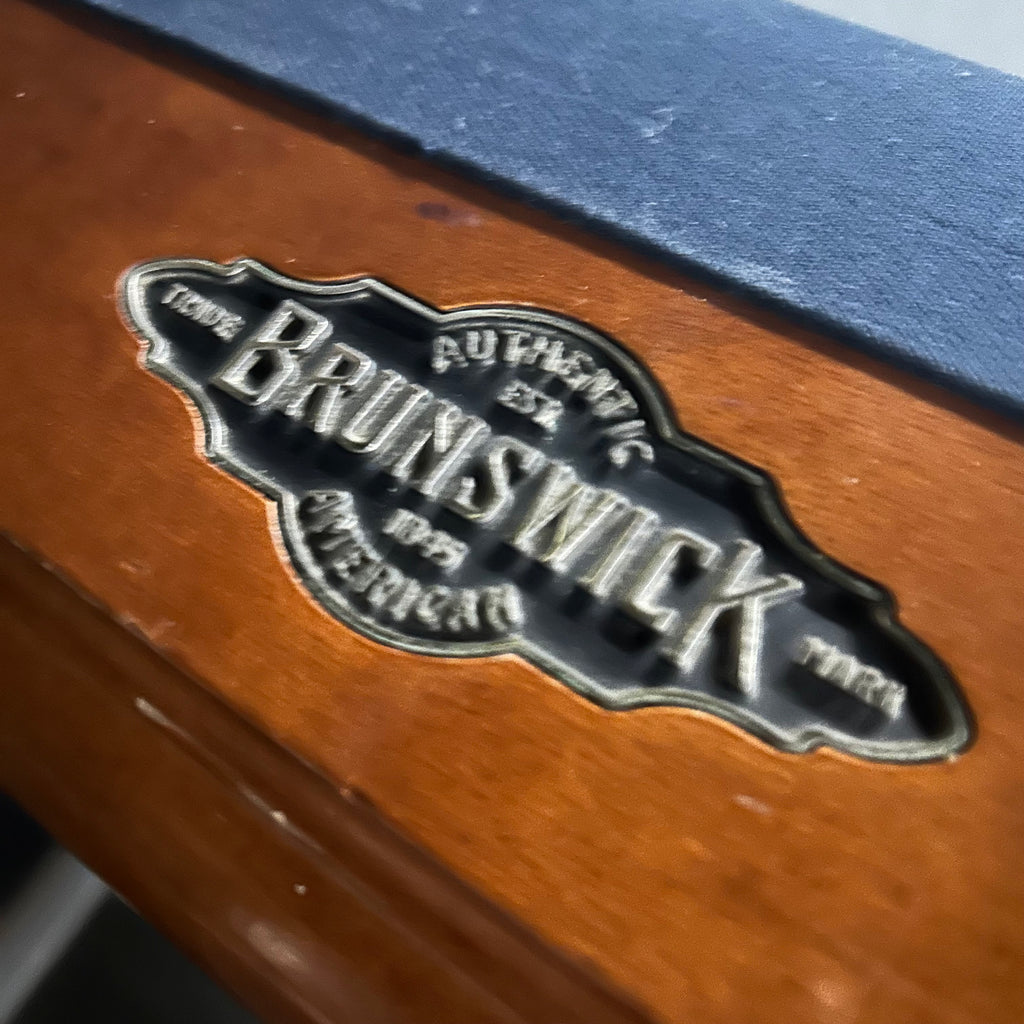 Closeup of brunswick logo on rail with blue rail felt