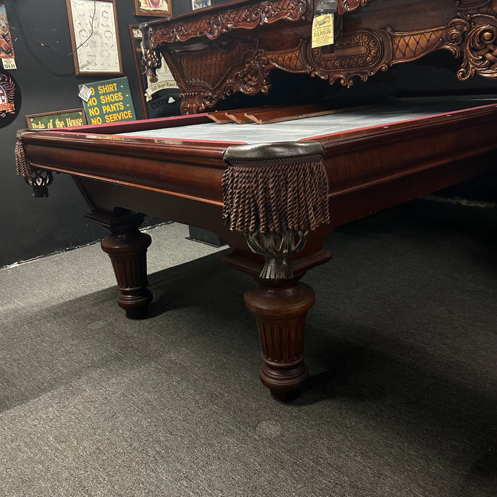 Corner view of pool table in mahogany finish with fringe pocket and round leg 