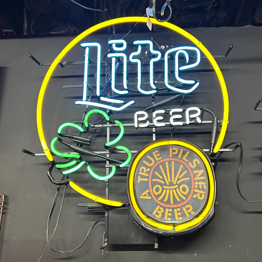 yellow circle neon with lite beer and green shamrock with a true pilsner written inside