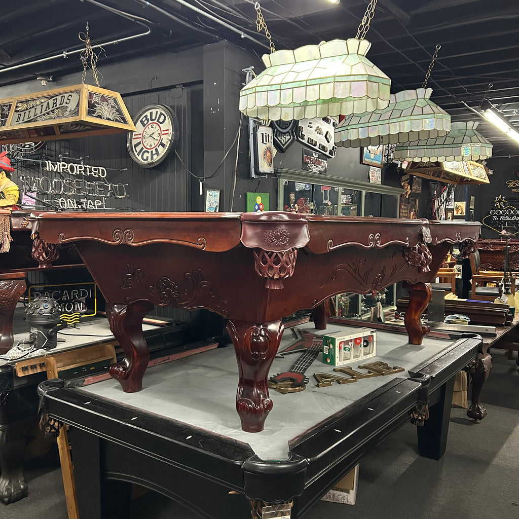 Overall view from left side of pool table in mahogany finish with shield pocket and rams horn leg
