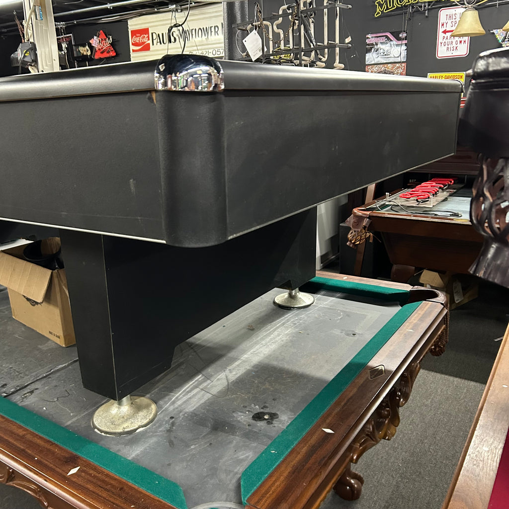 Corner view of pool table with black finish and pedestal base leg