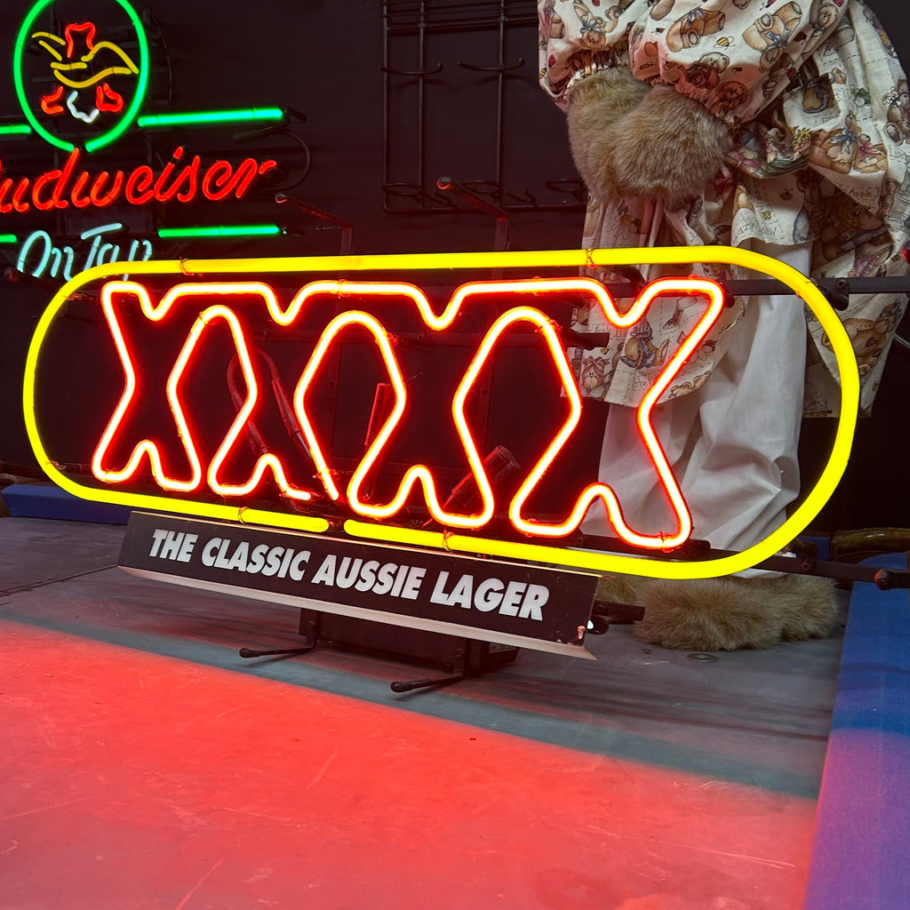 Neon light with yellow circle and XXXX in red, the classic aussie lager underneath