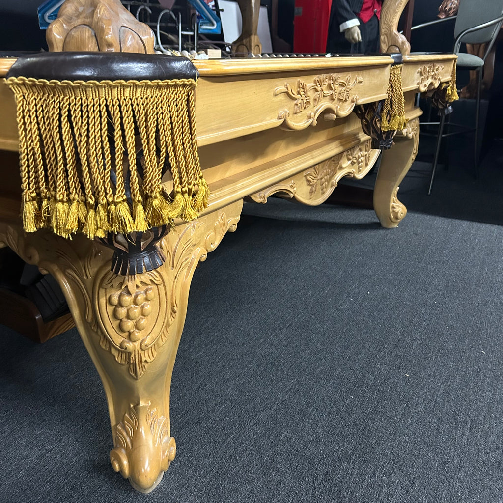 Side view of natural cabinet with gold fringe pocket and ornate legs