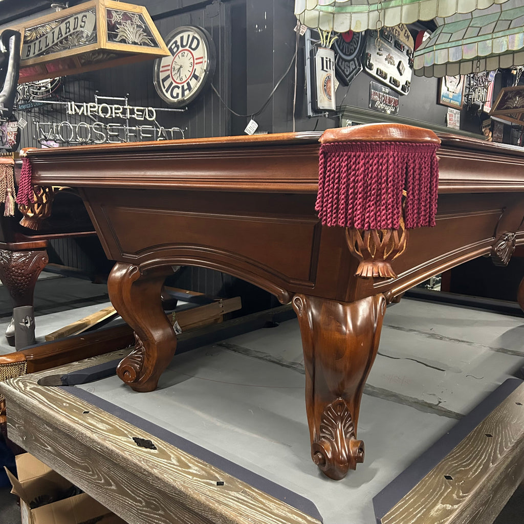 Corner view of pool table with rams horn leg and burgundy fringe pocket