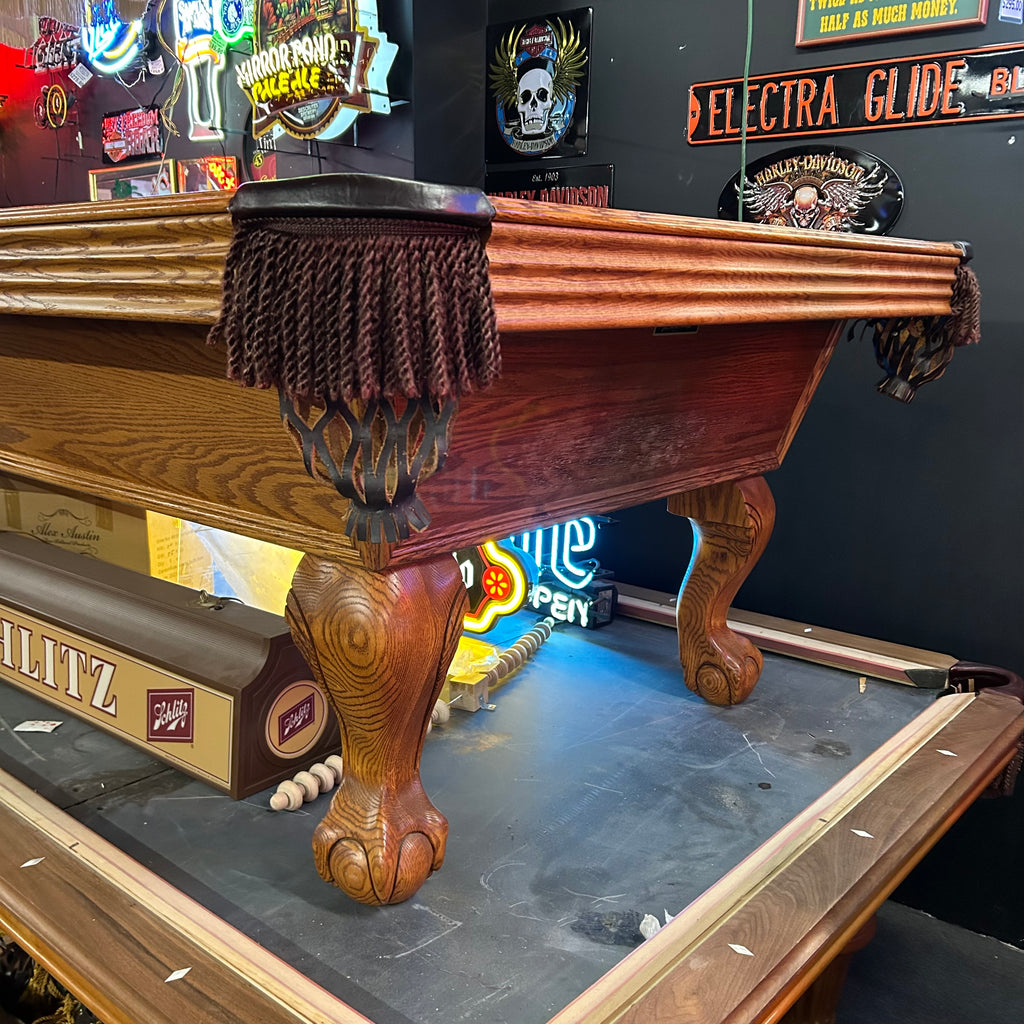 Right corner view of Olhausen oak pool table with ball and claw leg and fringe pocket