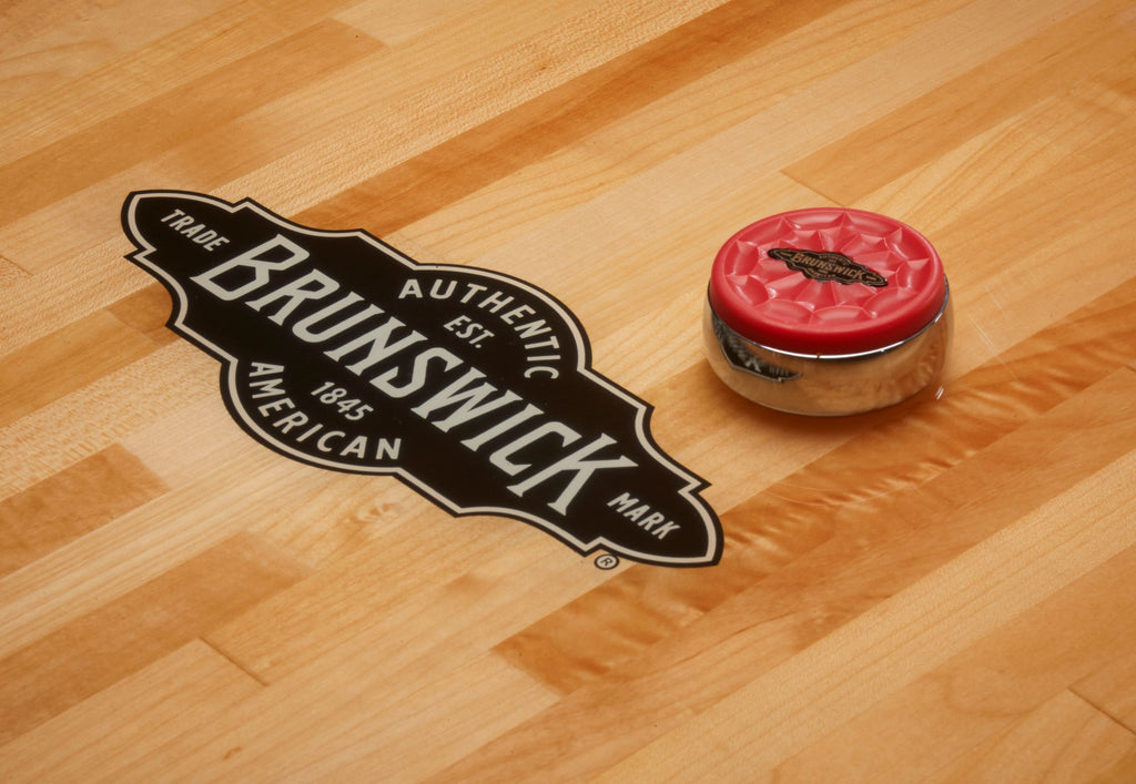 shuffleboard play surface with red puck and brunswick logo