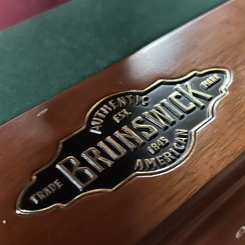 Brunswick logo on pool table rail with red and green cloth