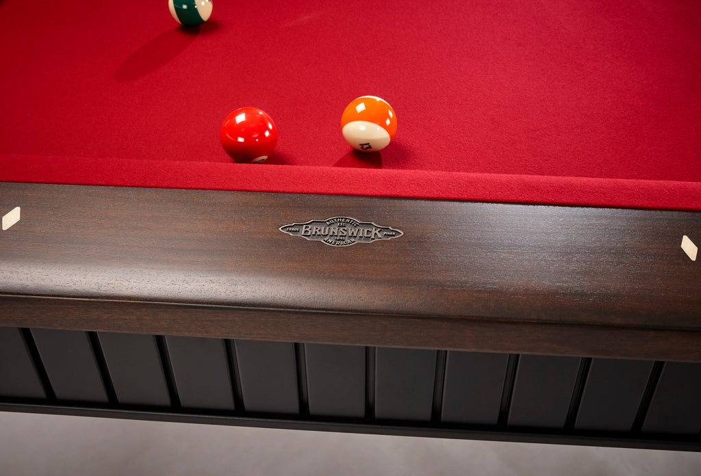 Front view of brunswick logo on pool table rail with red felt