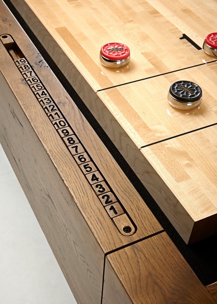 Shuffleboard built in numbered scorers on rail with play surface and pucks