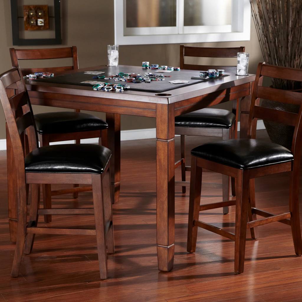 Square poker table with cards and glasses and 4 chairs in room with chips on table