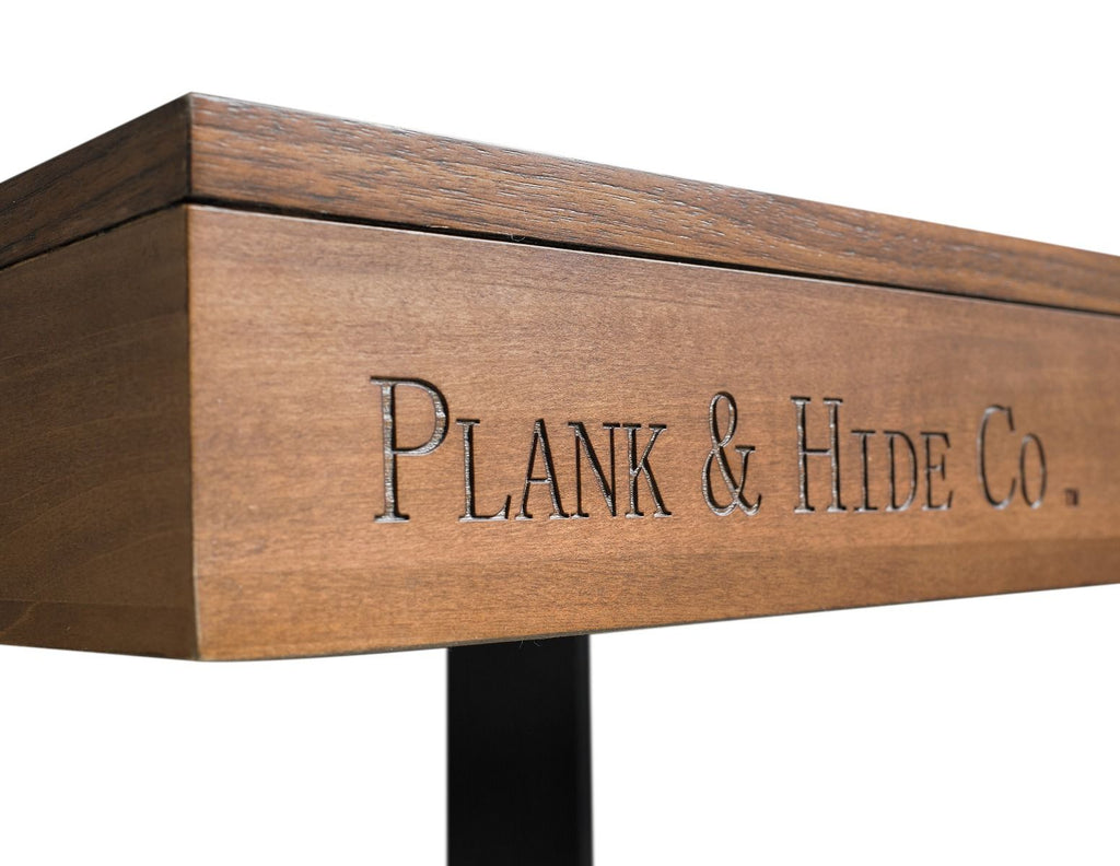 Plannk and hide co closeup engraved into walnut side of table