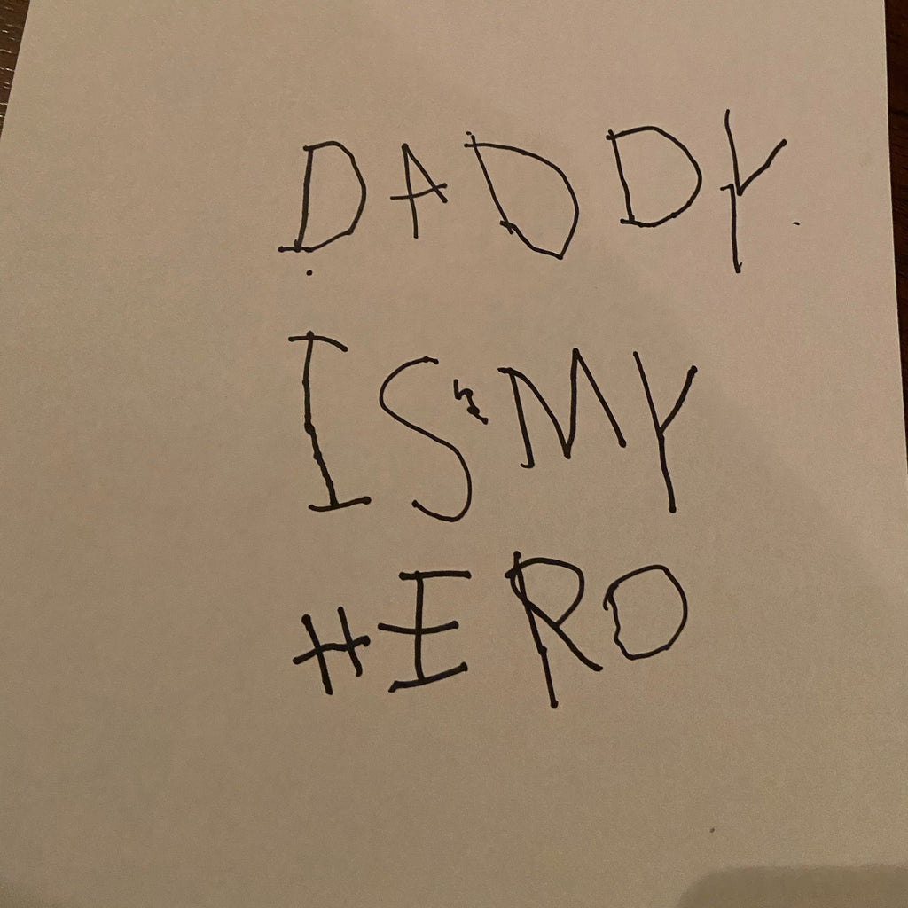 Paper with Daddy is my Hero written on it